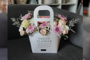 Pink, purple and white flowers arrangement in a bag